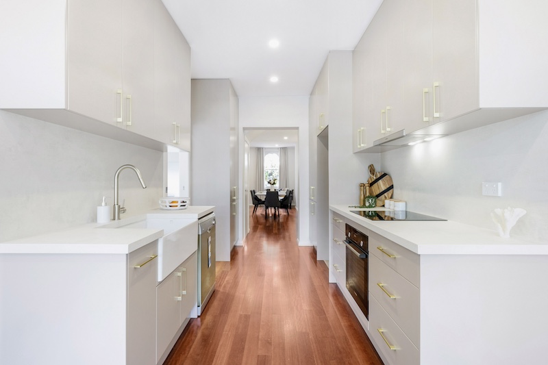 Discover an exquisite kitchen renovation featuring a modern design that combines functionality with style, crafted by Dura Group, the trusted Sydney-based building company. This sleek kitchen showcases high-quality cabinetry, state-of-the-art appliances, and elegant fixtures that enhance both aesthetics and practicality. The use of warm, hardwood flooring complements the bright, spacious layout, creating a welcoming environment for culinary creativity and family gatherings. Dura Group, led by the experienced Mark, brings 27 years of expertise in home transformations across the Sutherland Shire, Bayside, Inner West, Georges River, and Randwick regions. Specializing in home renovations, kitchen upgrades, and extensions, Dura Group partners with homeowners to deliver tailored building solutions, emphasizing budget-conscious planning, time efficiency, and transparent communication. Let this beautifully remodeled kitchen be the centerpiece of your dream home. Contact Dura Group today to begin your renovation journey and experience unmatched quality and service from a family-owned company that puts homeowners first.