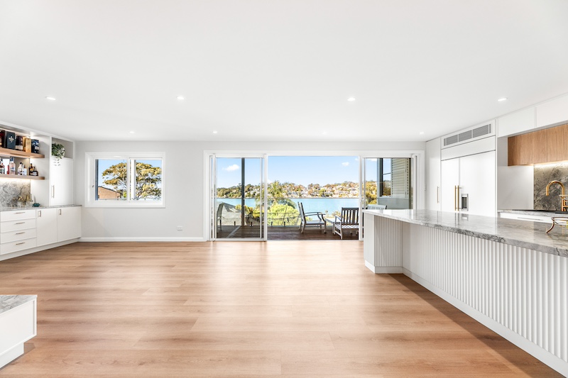 Experience the beauty of modern home design with Dura Group’s exquisite open plan kitchen. This expansive space showcases luxurious hardwood flooring and elegant countertops that seamlessly blend style and functionality. Large sliding glass doors open to reveal breathtaking waterfront views, creating a perfect harmony between indoor and outdoor living. At Dura Group, based in Sydney, every renovation is custom-tailored to suit your unique needs, leveraging over 27 years of construction expertise. We prioritize time efficiency, budget-conscious planning, and consistent communication to ensure your project is completed without compromising quality. With a commitment to transparency and trust, we focus on delivering a homeowner-first approach that guarantees satisfaction. Whether you’re considering a kitchen upgrade or a complete home renovation, Dura Group offers solutions that enhance your lifestyle. Transform your vision into reality with our expert craftsmanship and personalized service. Contact us today to start your renovation journey and experience the Dura Group difference!