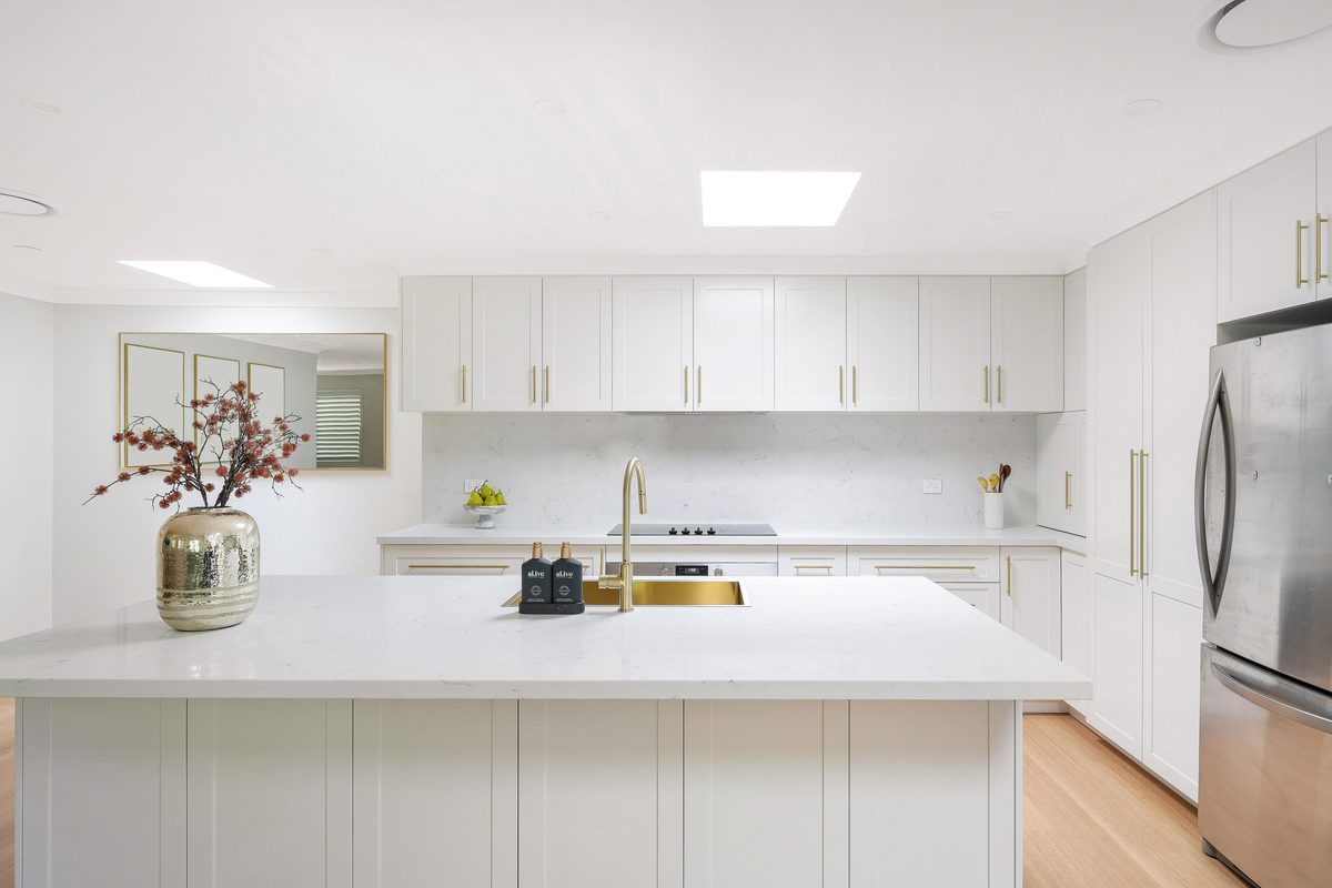 White kitchen renovation with skylight and island bench